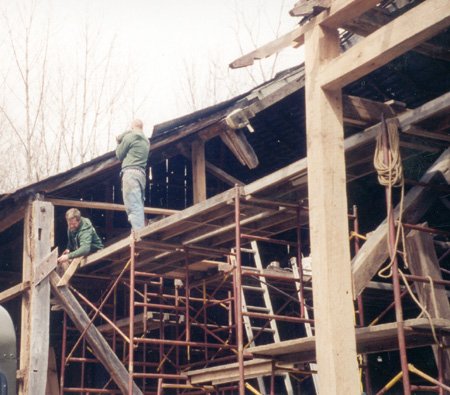 Dahlgren Street barn restoration project in progress, timber framers at work installing new bearing posts and beams.