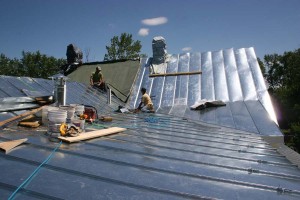 As with any re-roofing project care must be taken to protect the contents of the building.  Here we can see portions of the old roof that were partially removed yet kept in place to keep the building dry.  Installation of a roof of this quality can take a crew of four upto or a little longer than a month.