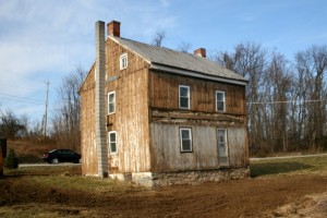 Missing sections of siding indicate that the porch roof was indeed original to the structure, or a very early addition.