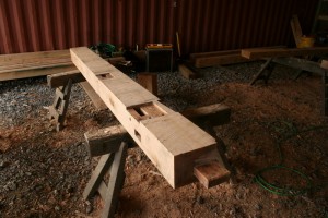 The design of this building calls for the floor bearing timbers and ties to intersect the posts on the same plane.  That requires heavy bearing shoulders and "spline" joints.